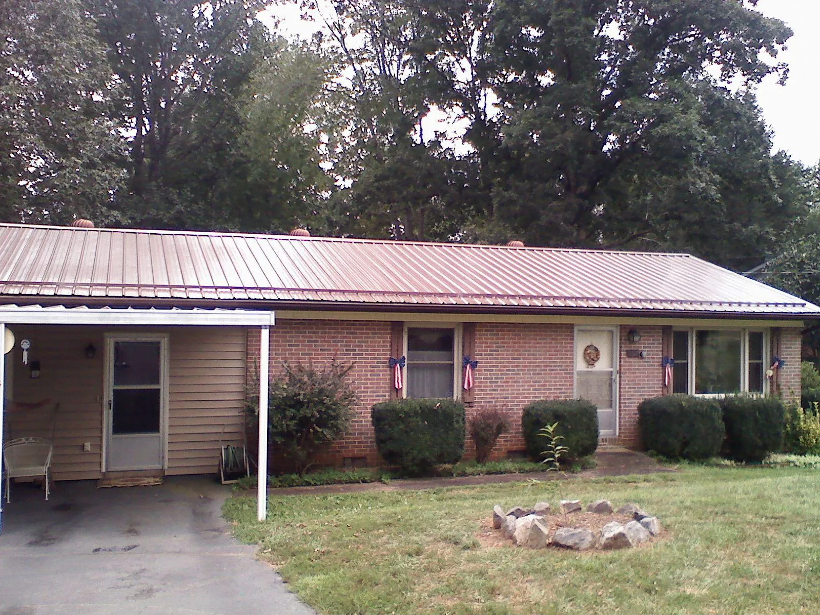 Bronze metal roof and carport on a brick ranch home — Roof Repair work by our crew in Whitsett