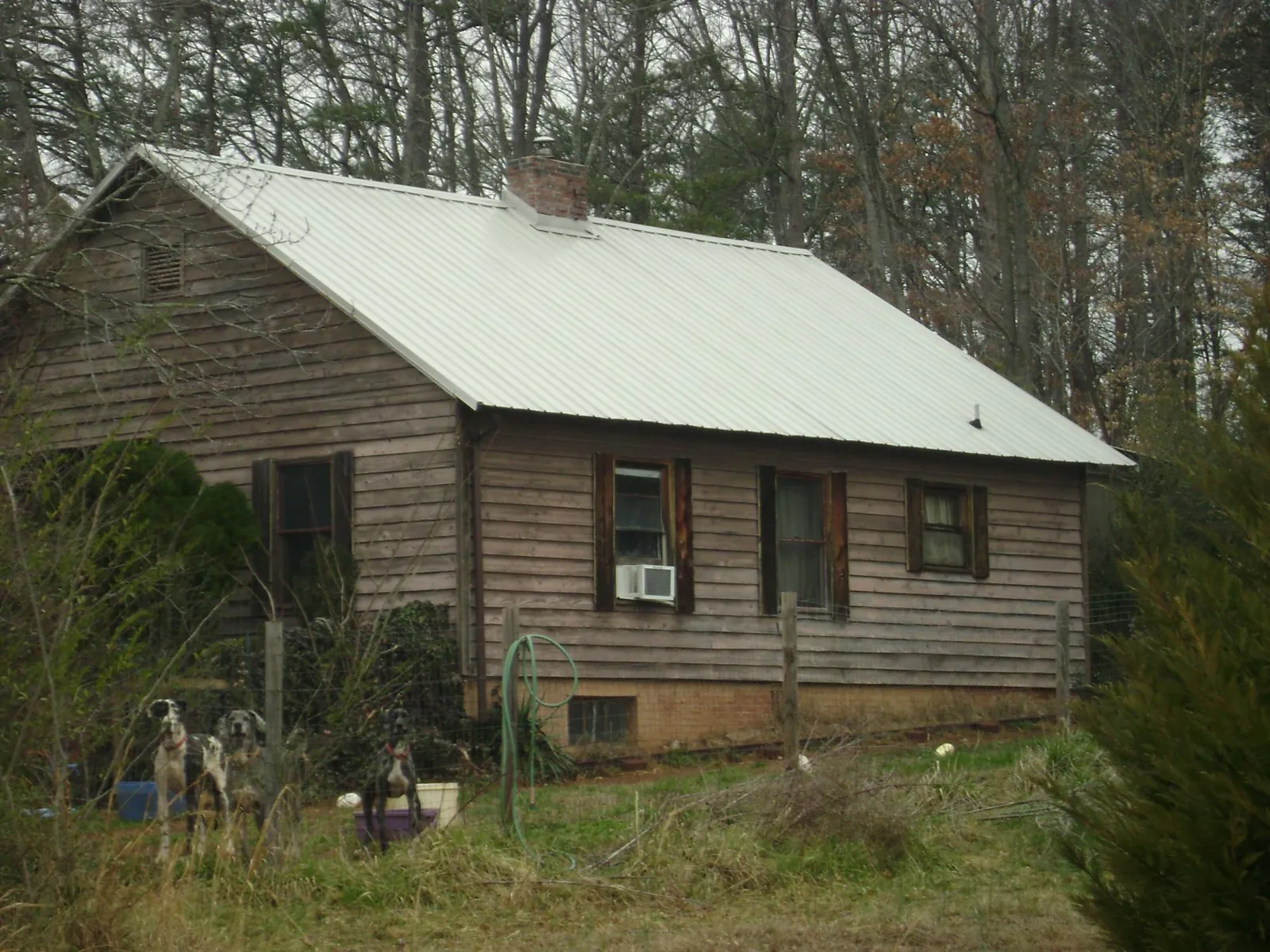 White metal roof on an old wood sided farmhouse, from a Metal Roof Installation job in Whitsett